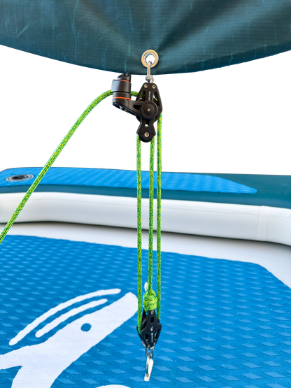 Close-up of a pulley system on an inflatable watercraft with green ropes.