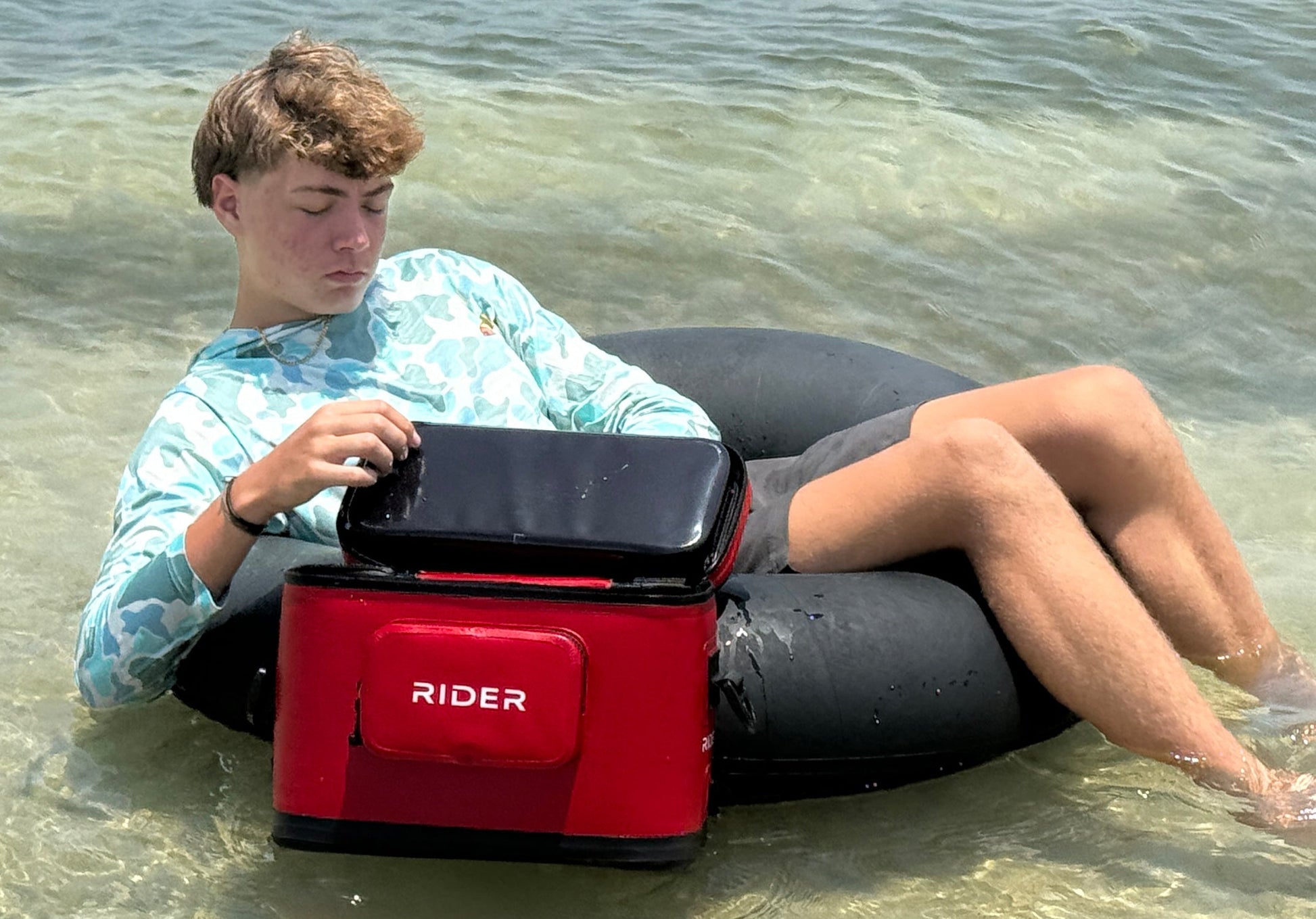 guy on tube in water with cooler