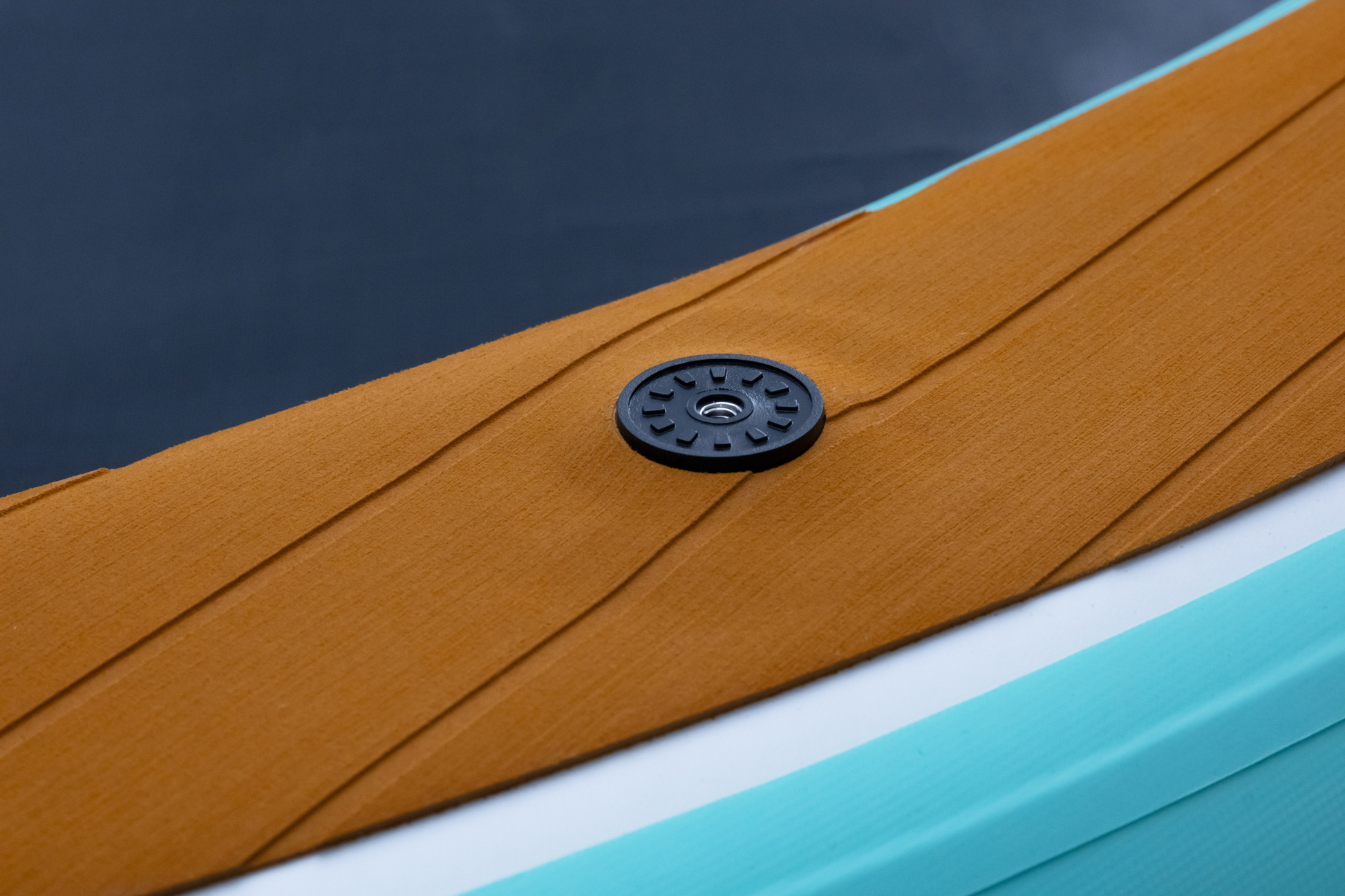 Close-up of a brown leather surface with a black button and blue background