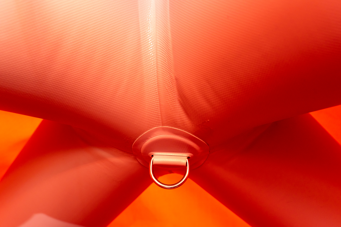 Close-up of a red fabric bow with a metal ring in the center.
