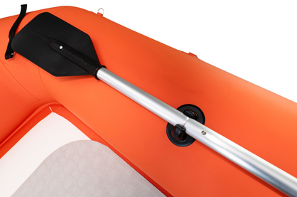 Paddle attached to an orange inflatable boat on a white background