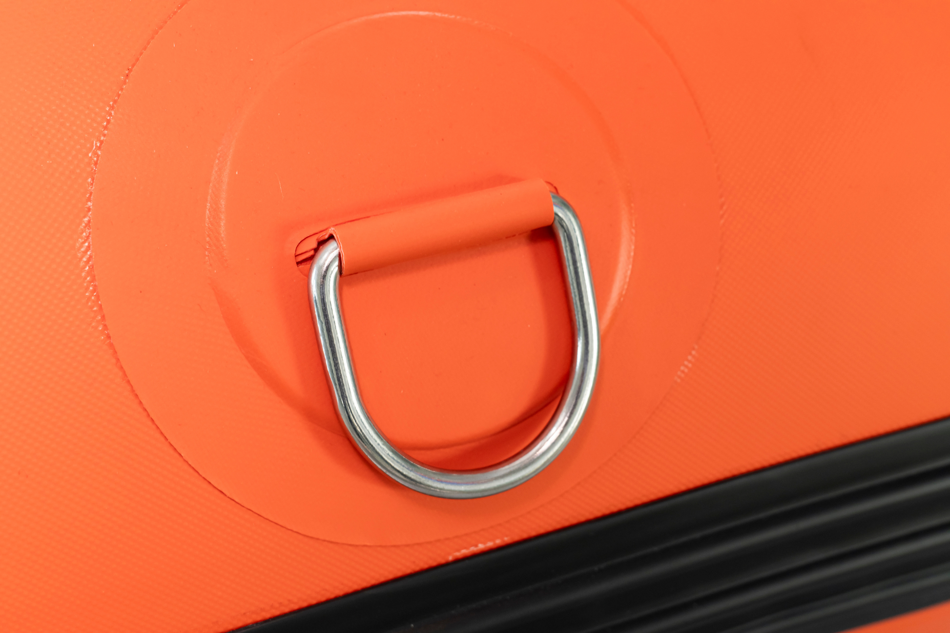Close-up of an orange object with a metal ring handle