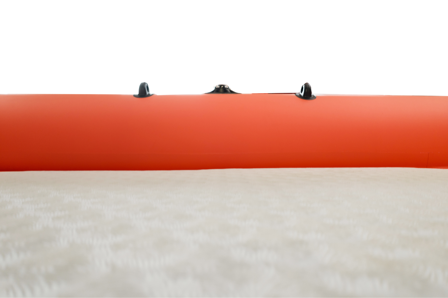 Close-up of an orange inflatable boat with black floor straps on a white background