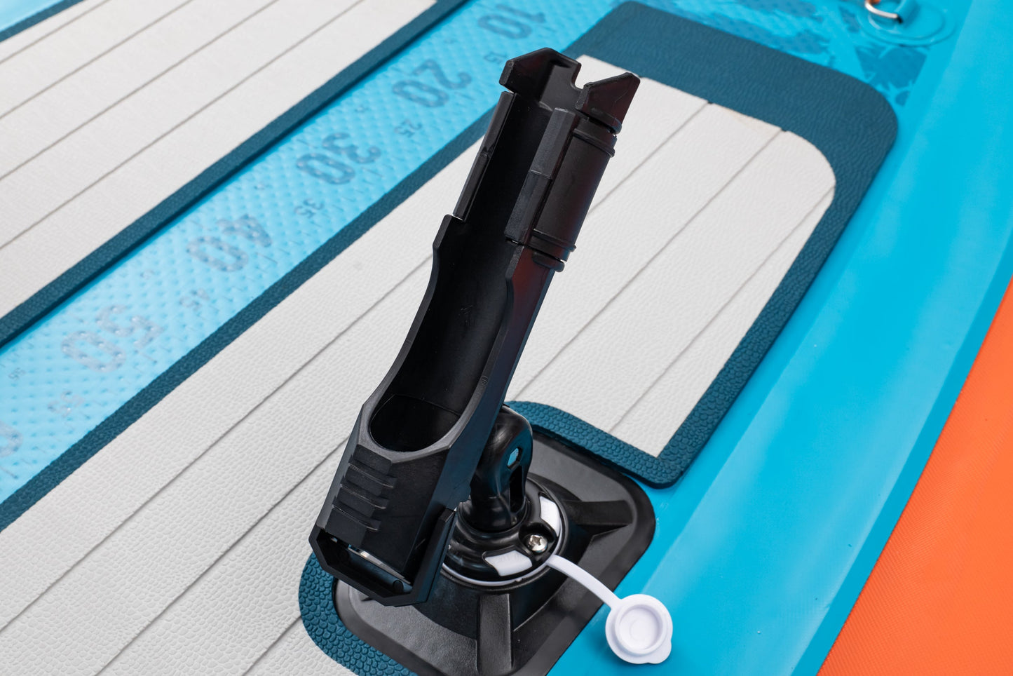 Close-up of a black pump handle on an inflatable boat with blue and orange sides.