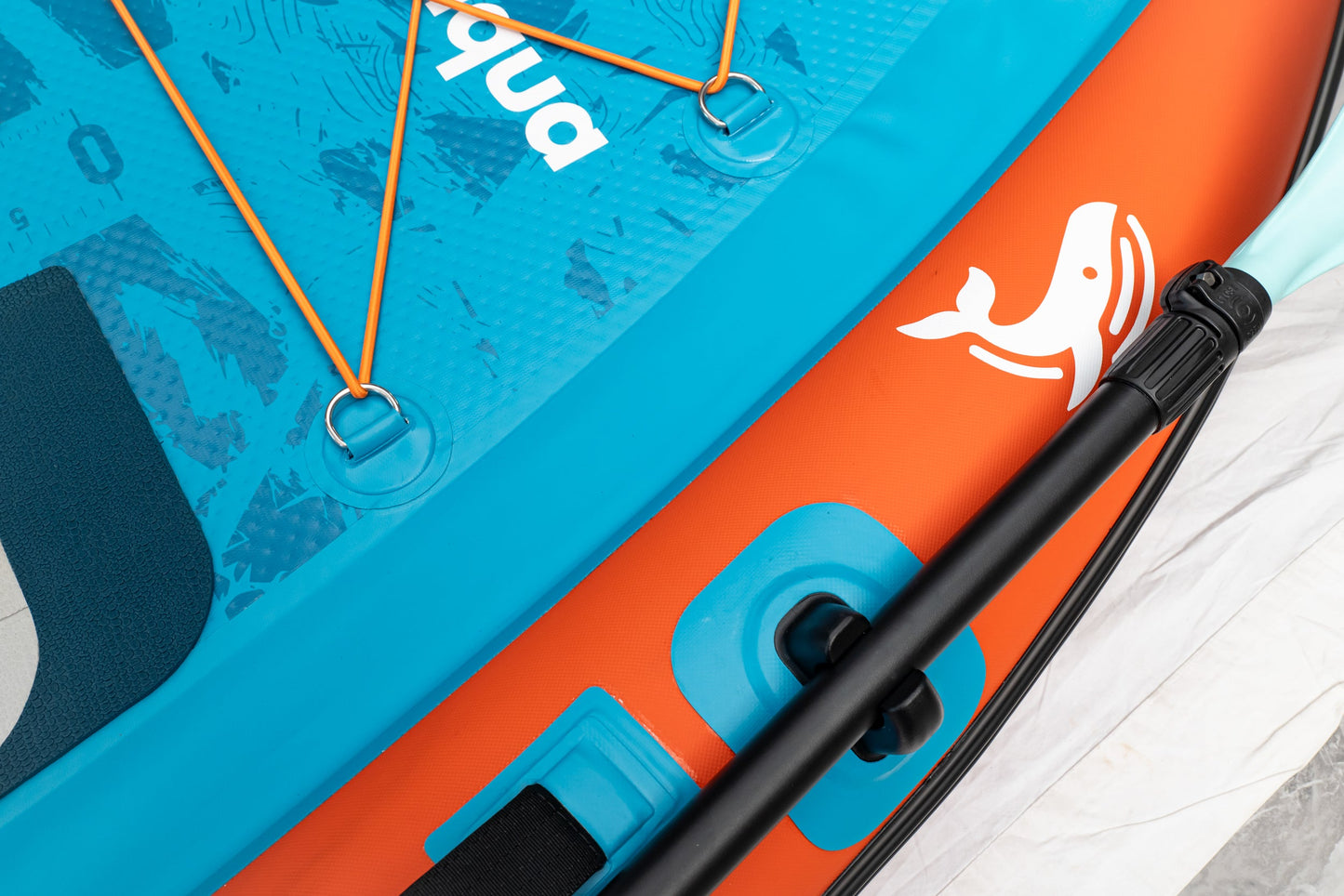 Close-up of a blue and orange inflatable paddle board with a brand logo.