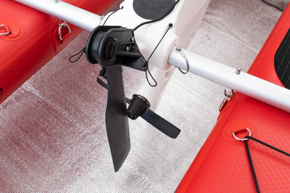 Close-up of a red and white drone with a propeller on a textured surface